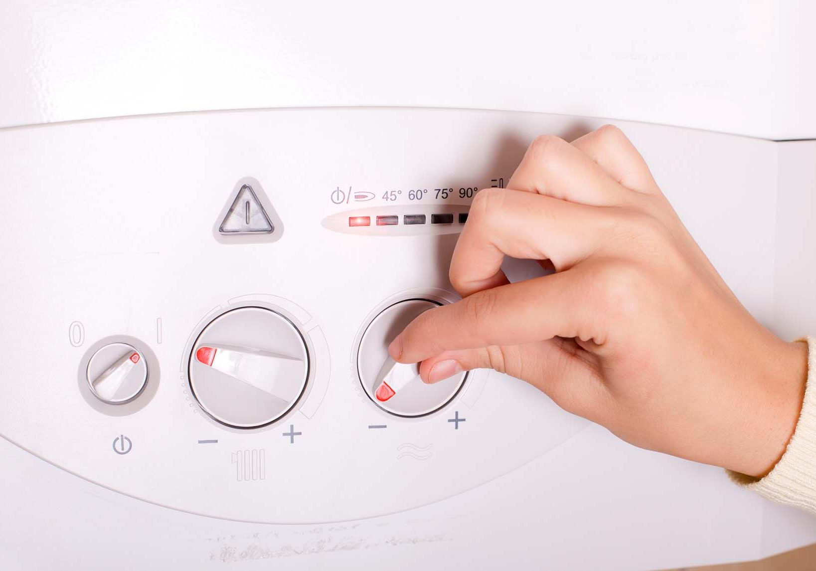 Womans hand using boiler controls
